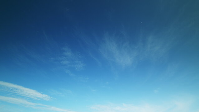 Time lapse. A beautifully clear blue sky scattered with subtle and soft clouds can be seen today