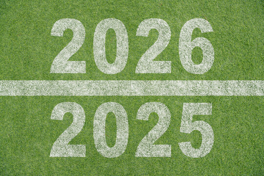 New year 2026 concept, beginning of success. Text 2026 written on soccer pitch and male runner preparing for the new year. Concept of challenge or career path and change.