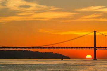Golden hour over the Tagus River with Lisbon iconic 25 de Abril Bridge. Ideal for souvenirs postcards magnets editorial design blogs and travel websites.