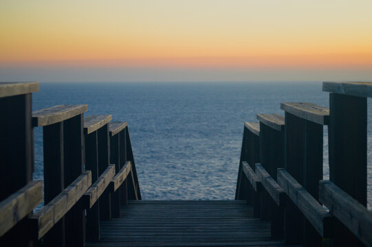 Escaleras de madera para ver el atardecer en el mar