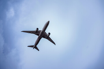 Modern passenger airplane flying in cloudy sky