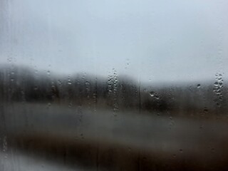 Blurry view out the window covered in water droplets