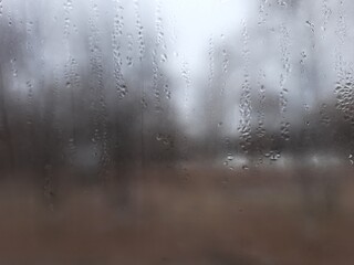 Blurry view out the window covered in water droplets