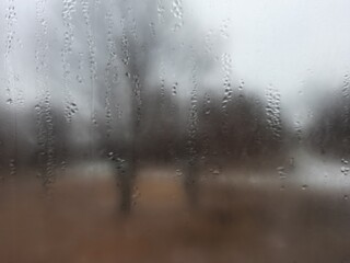 Blurry view out the window covered in water droplets