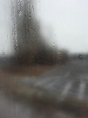 Blurry view out the window covered in water droplets