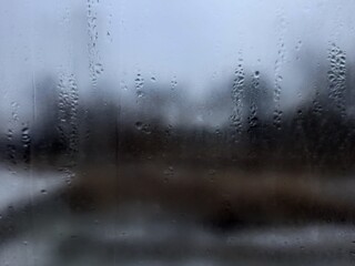 Blurry view out the window covered in water droplets