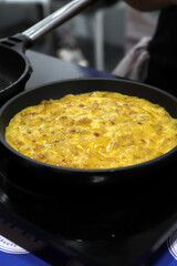 tortilla de patata friéndose en una sartén en la cocina