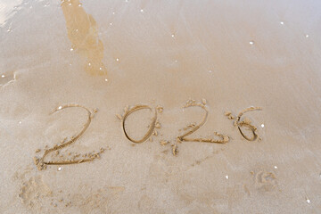 2026 numbers written in the sand. New year goal on the beach. Sea background. Copy space