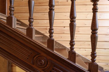 close-up shot of a wooden staircase featuring ornate balusters and detailed woodwork, set against a wood-paneled wall