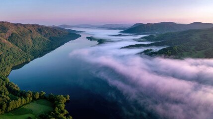 Fototapeta premium Aerial panorama of lake district at dawn, morning mist over calm water, forested hills in soft light, serene and magical atmosphere for landscape stock photo