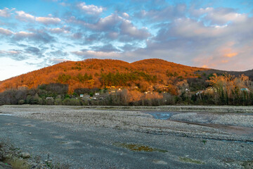 A colorful landscape with high mountains, a beautiful winding river, an autumn forest, and a blue...
