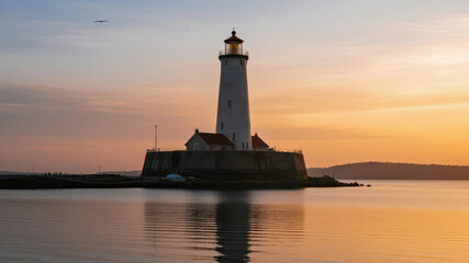 Lighthouse at Sunset with Calm Waters and Soft Sky