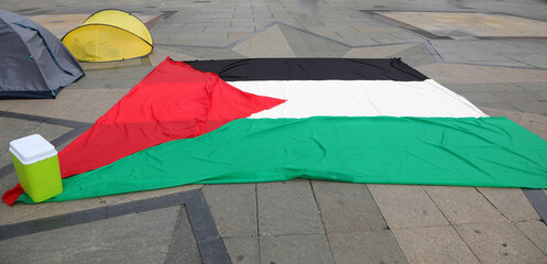 Large Palestinian flag spread across public square during a demonstration by activists
