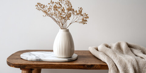 White vase dried flowers marble coaster wooden bench knitted blanket image