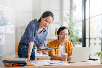 business development teamwork is standing and discussing a new rebranding and strategy. The two...