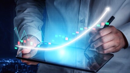 A business professional engages with a tablet to analyze financial data represented by colorful...