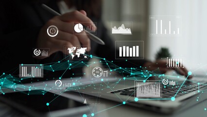 A business professional engages with various digital graphics and charts on a laptop, showcasing...