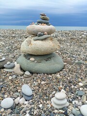A large zen cairn of stones representing stability and tranquility on a pebble beach