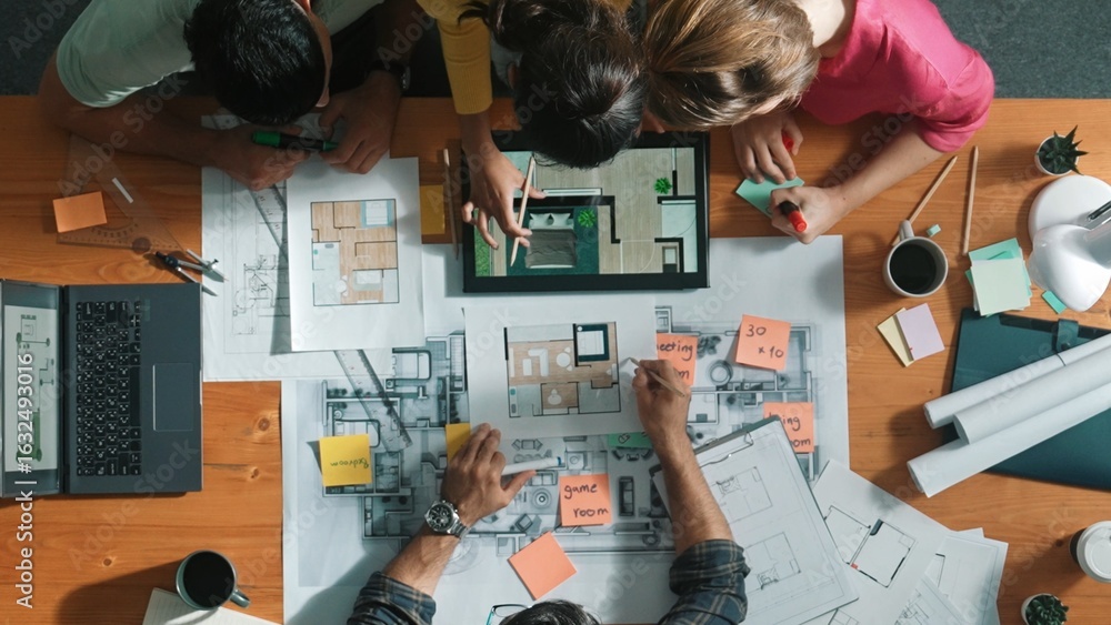 Poster top down view of manager writing at blueprint while marketing team plans design. aerial view of arch