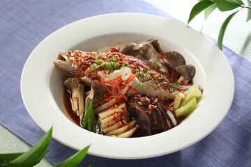 Whole yellow croaker braised with king oyster, oyster, and shiitake mushrooms in spicy soy chili glaze. A dish by Hanshunseop.