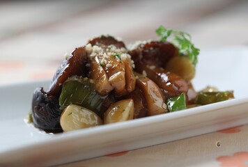 Modern-style soy braised king oyster mushrooms with garlic. Soft texture and clean finish. A dish by Master Chef Hanshunseop. Photographed in Korea.