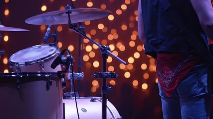 Close up of a drum kit and a musician on stage during a live concert with blurred bokeh lights capturing the energy of a music performance - Powered by Adobe