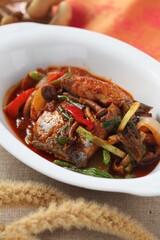 Traditional braised hairtail fish cooked with velvet shank mushrooms, vegetables, and chili seasoning. A dish by Master Chef Hanshunseop. Photographed in Korea.