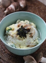 Warm rice served with soft egg, pine mushrooms, onions, and seaweed in light soup. A comfort dish by Master Chef Hanshunseop. Photographed in Korea.