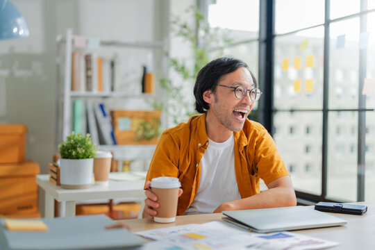 Businessman stretching in the office after finish project work man is happy relax clam positive laught smile close laptop finish work waiting for weekend vacation at home office