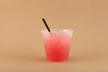 Frozen Slush or Chipped Ice Drink in disposable plastic cup with drinking straw. Spanish granizado....