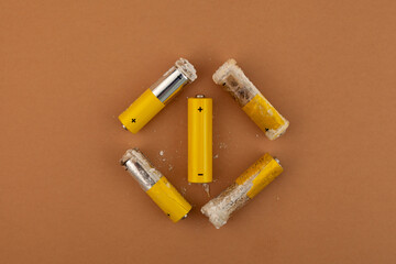 Oxidized and leaked AA alkaline batteries. White powder Potassium hydroxide was formed by leakage of alkaline electrolyte. Hydroxides and carbonates are dangerous, powder caustic