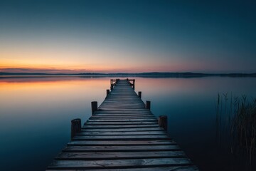 Fototapeta premium Tranquil wooden pier on calm lake at sunrise