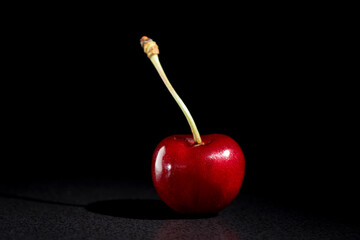 Juicy red cherry on black background. Fresh sweet cherry, closeup