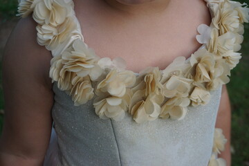 Mädchen mit weißem Sommerkleid mit champagnerfarbenem goldenem Blumenkragen 