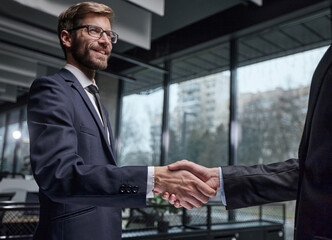 Two men shaking hands in a business setting