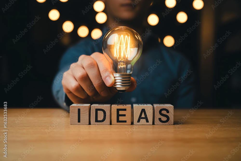 Aufkleber concept of innovative ideas and creative thinking represented by a light bulb held above wooden bloc