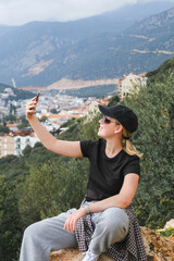 Solo female traveler enjoys scenic coastal view during eco-conscious hiking retreat. Digital nomad lifestyle, nature detox, and mindful escape for remote work and inner balance.