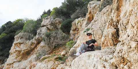 Solo female traveler enjoys scenic coastal view during eco-conscious hiking retreat. Digital nomad...