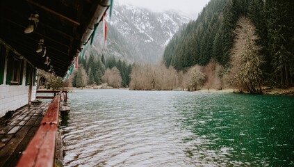 Rustic cabin overlooking a tranquil lake, misty mountains in the background