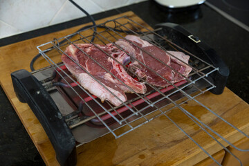 Detalhe de carne de porco a cozinhar em grelhador elétrico. Refeição saudavel, proteína animal....