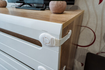 A child safety lock is firmly and securely attached to a dresser to effectively ensure the safety...