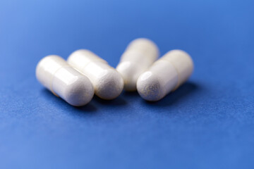 Creatine capsules on paper background. Soft focus. Close up. Copy space.