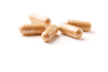 Ashwagandha (Withania somnifera) capsules. Concept for a healthy dietary supplementation. Bright paper background. Close up. Copy space.	