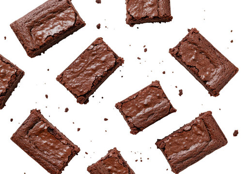 Deliciously rich chocolate brownie squares scattered across a dark surface isolated on transparent background