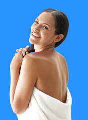Latin woman spa wearing bath towel after shower isolated on blue background.