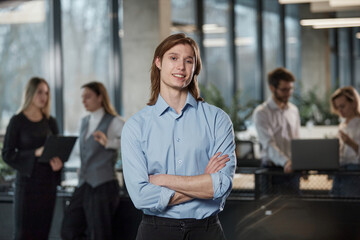 A man in a blue shirt stands in front of a group of people