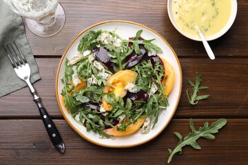 Tasty salad with arugula, blue cheese and vegetables on wooden table, flat lay