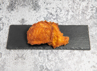 Crispy Fried Chicken Thigh on a Black Slate Plate side view of taiwan food