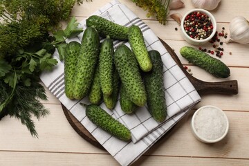 Making pickles. Fresh cucumbers, spices and herbs on light wooden table, flat lay