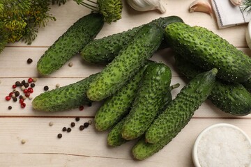 Making pickles. Fresh cucumbers, spices and dill on light wooden table, flat lay